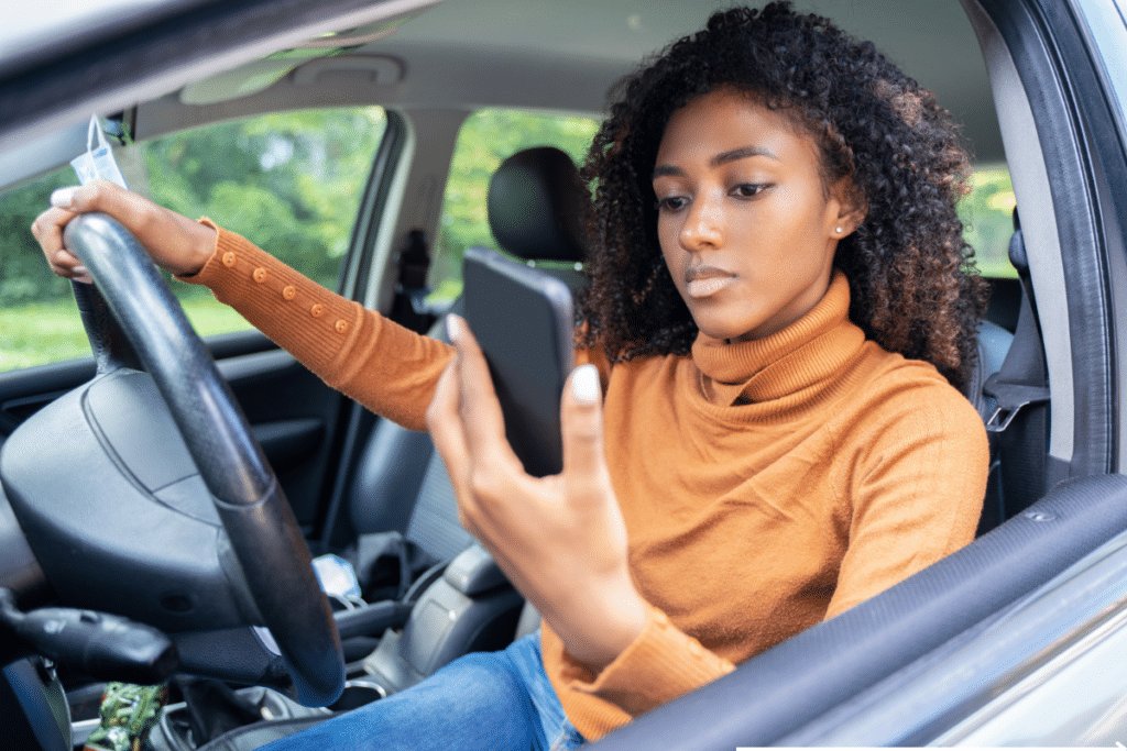 A woman driving distracted by her phone