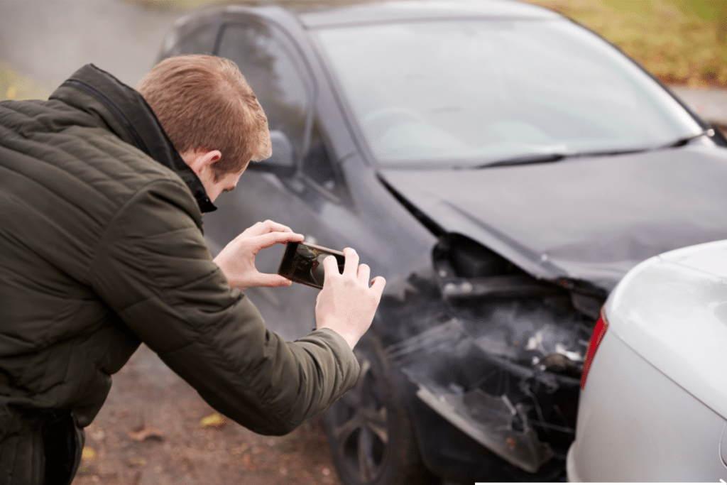 man snapping an accidented vehicle