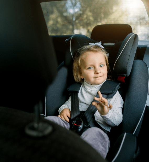 .A toddler fastened in a rear-facing car seat in the backseat of a car.